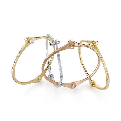 A group of skinny 18K gold Handcuff Bracelets in different color metals and diamond accents